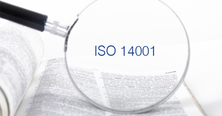 Bild von einer Lupe auf einem aufgeschlagenem Buch und in der Mitte von der Lupe steht ISO14001