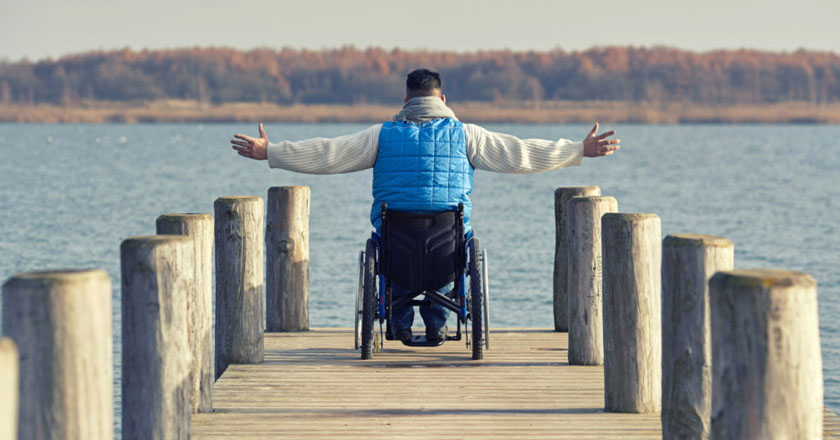 Bild von einem Mann im Rollstuhl an einem See